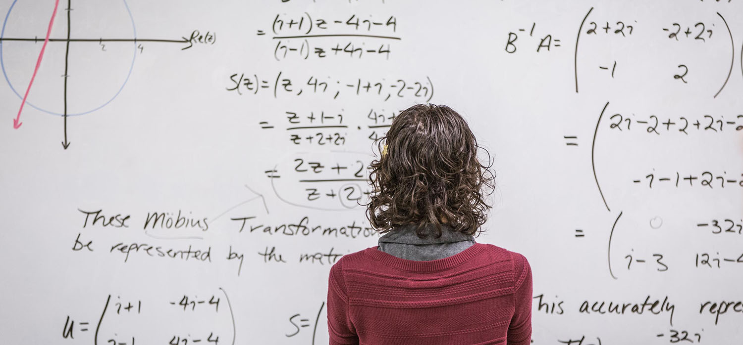 Studentin vor einer Tafel mit Formeln - ©Hill Street Studios/Tobin Rogers/Blend Images LLC